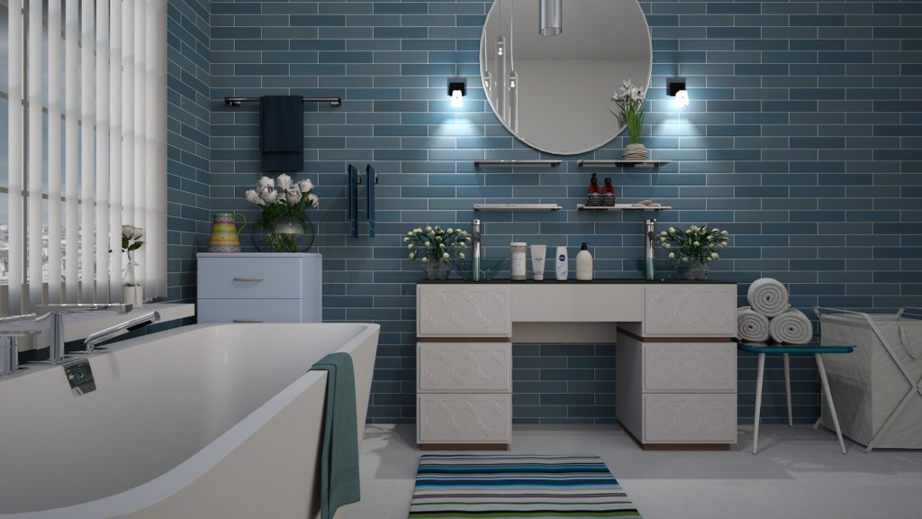 blue tile walled bathroom with white bathtub and sink