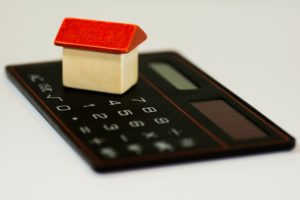miniature house on top of a calculator