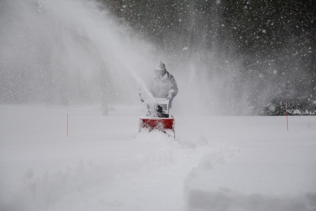 man pushing a snow blower
