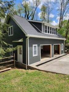 New garage in Pittsburgh with gray siding, white trim, and dormer windows.