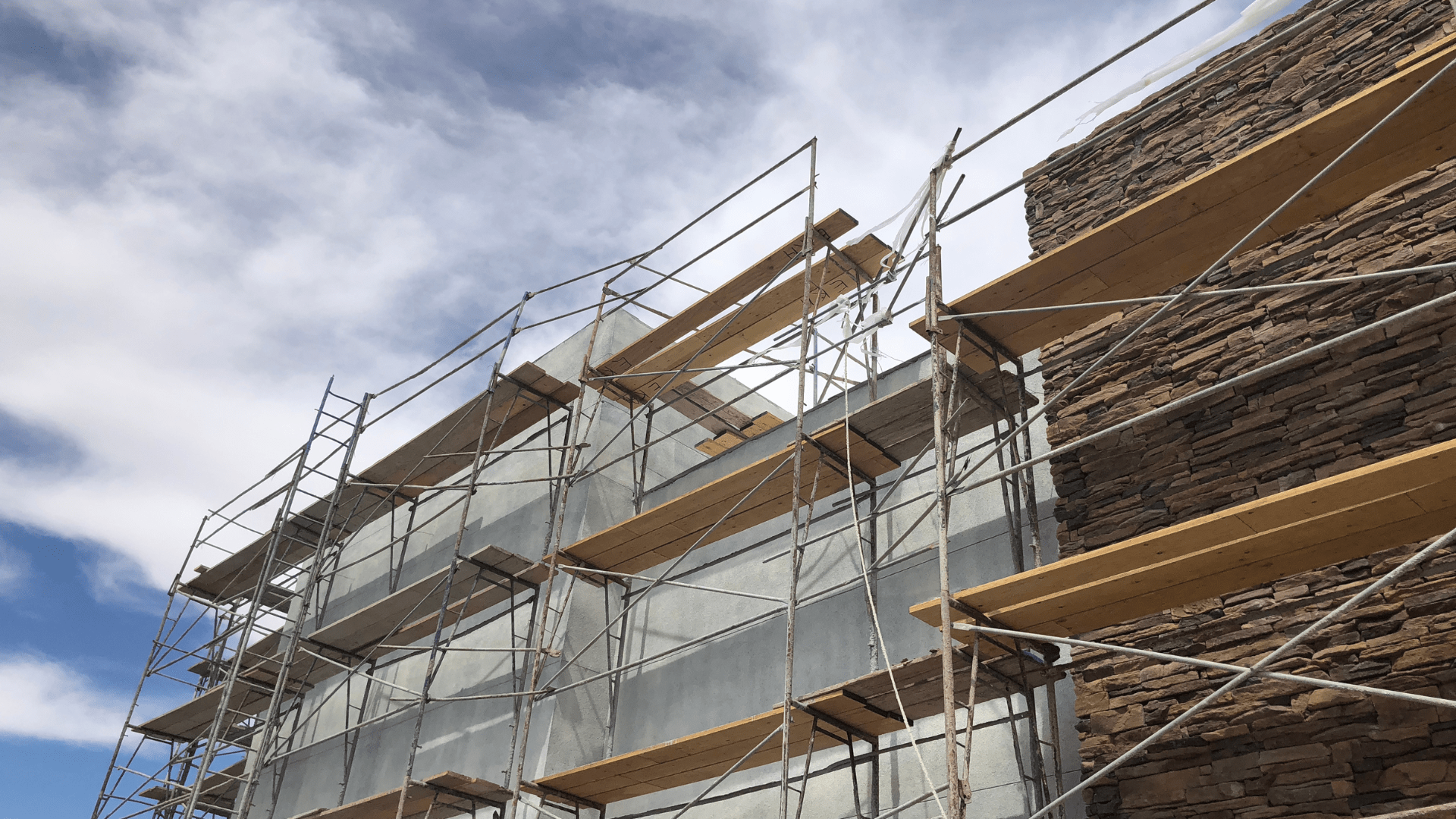 Scaffolding on a building under construction, with stone facade.