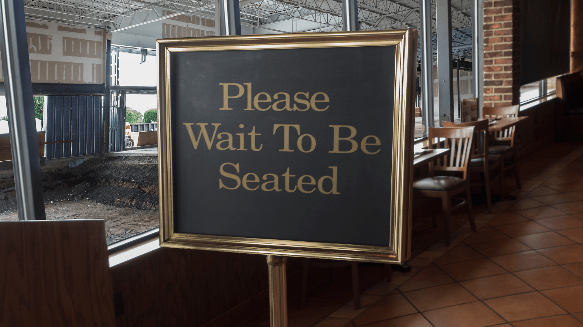Sign saying "Please Wait To Be Seated" in a restaurant undergoing fire damage restoration.