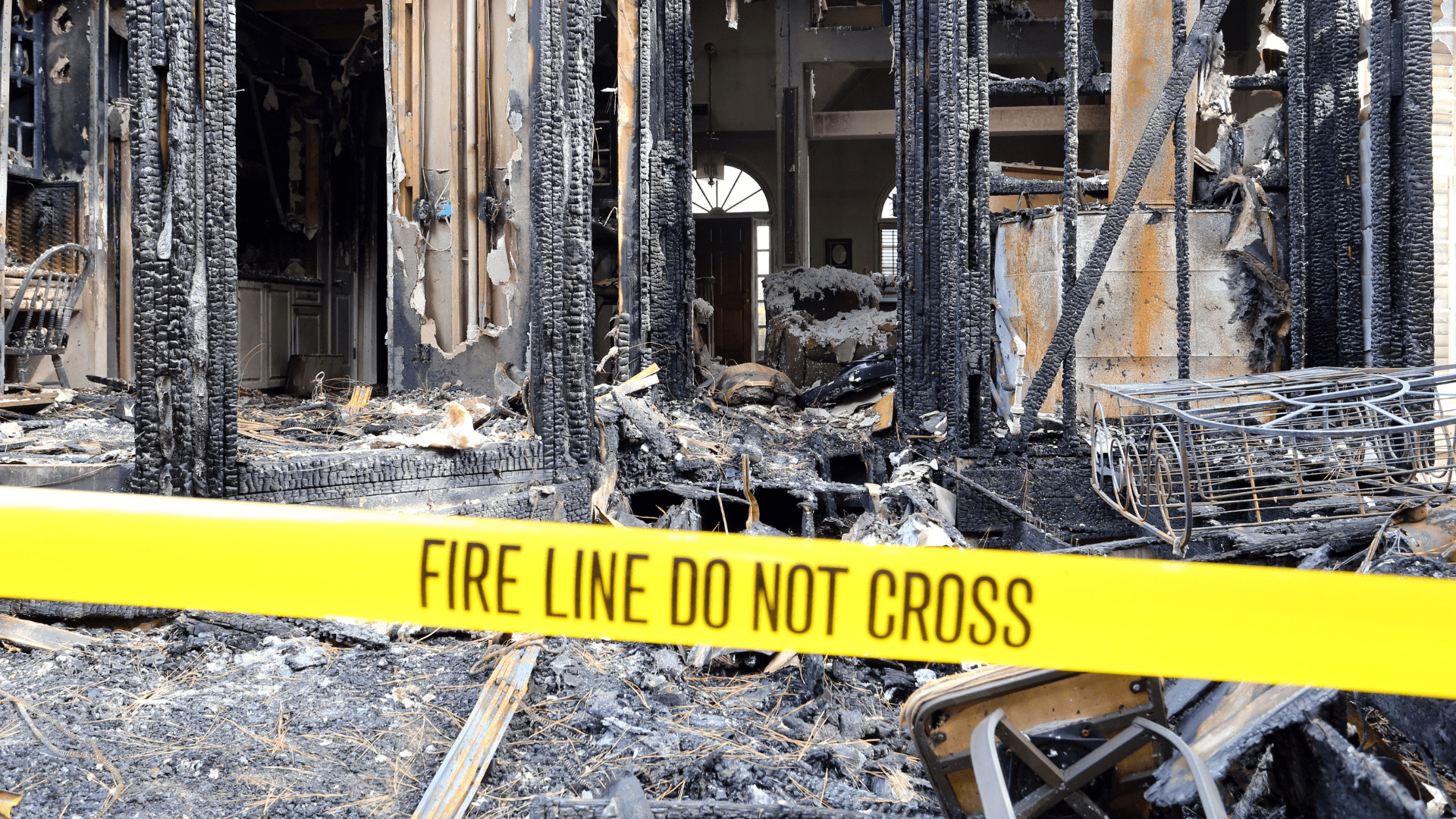 Fire damage restoration in Pittsburgh: Burned building behind "FIRE LINE DO NOT CROSS" tape.