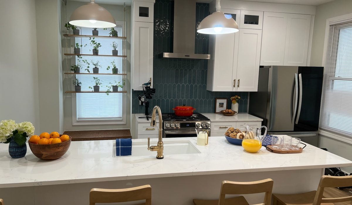 Bright, modern kitchen featuring white cabinets, a central island, and indoor plants. 3Rivers General Contracting.